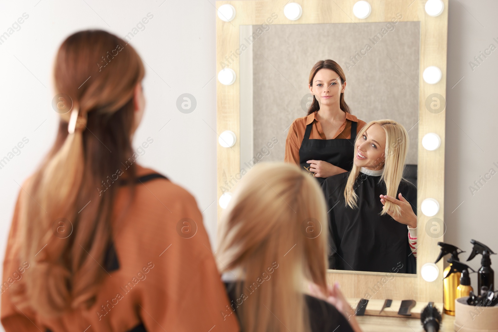 Photo of Hair cutting. Professional hairdresser working with client in salon, selective focus