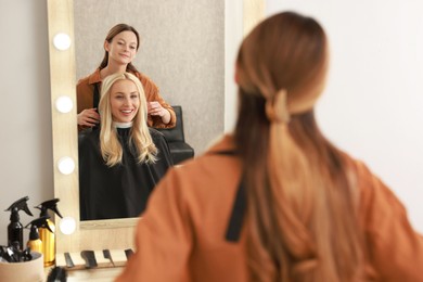 Photo of Hair cutting. Professional hairdresser working with client in salon, selective focus