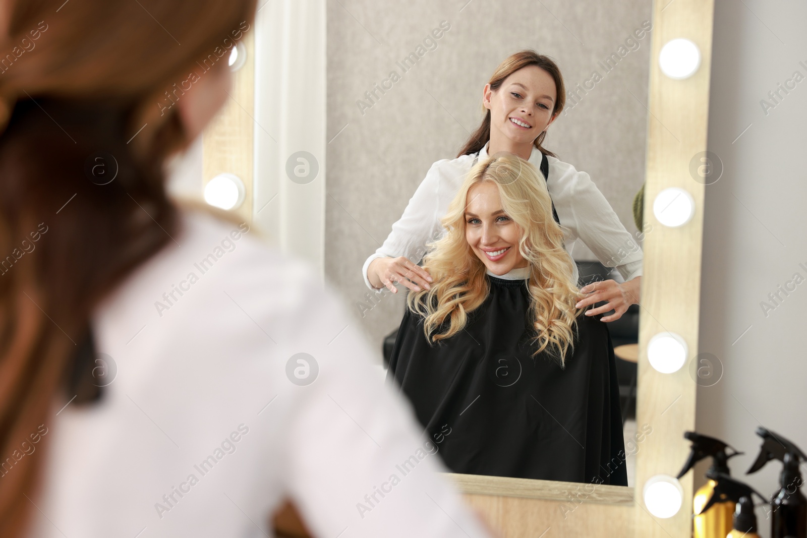 Photo of Hair cutting. Professional hairdresser working with client in salon, selective focus