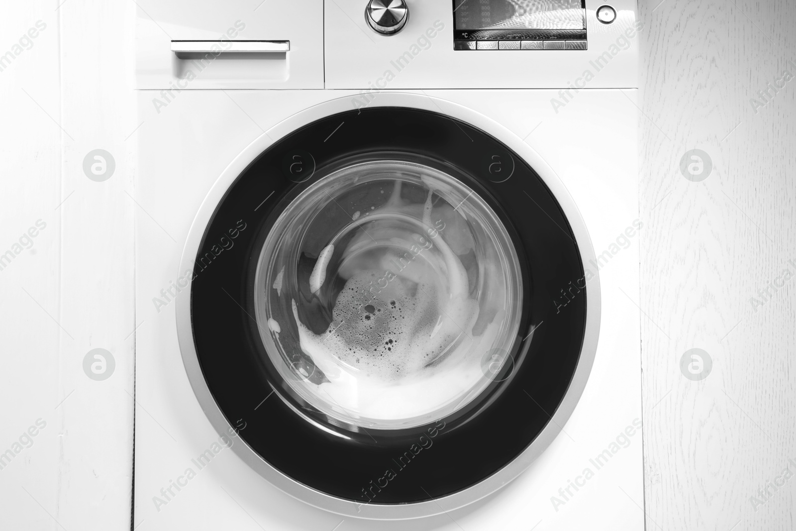 Photo of Washing machine with suds as background, closeup