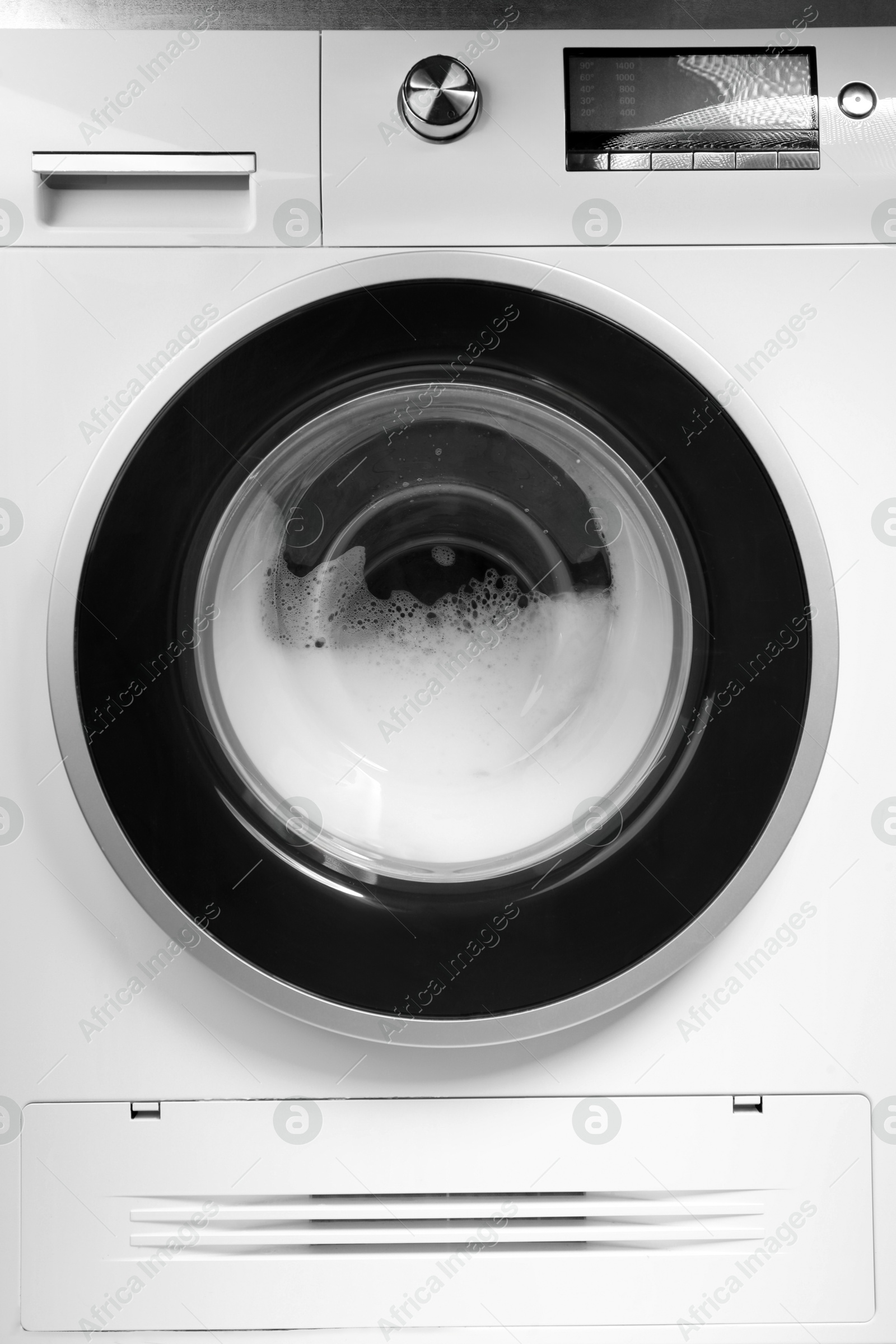 Photo of Washing machine with suds as background, closeup