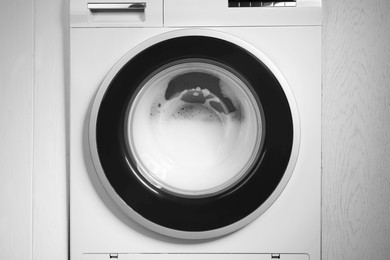 Photo of Washing machine with suds as background, closeup