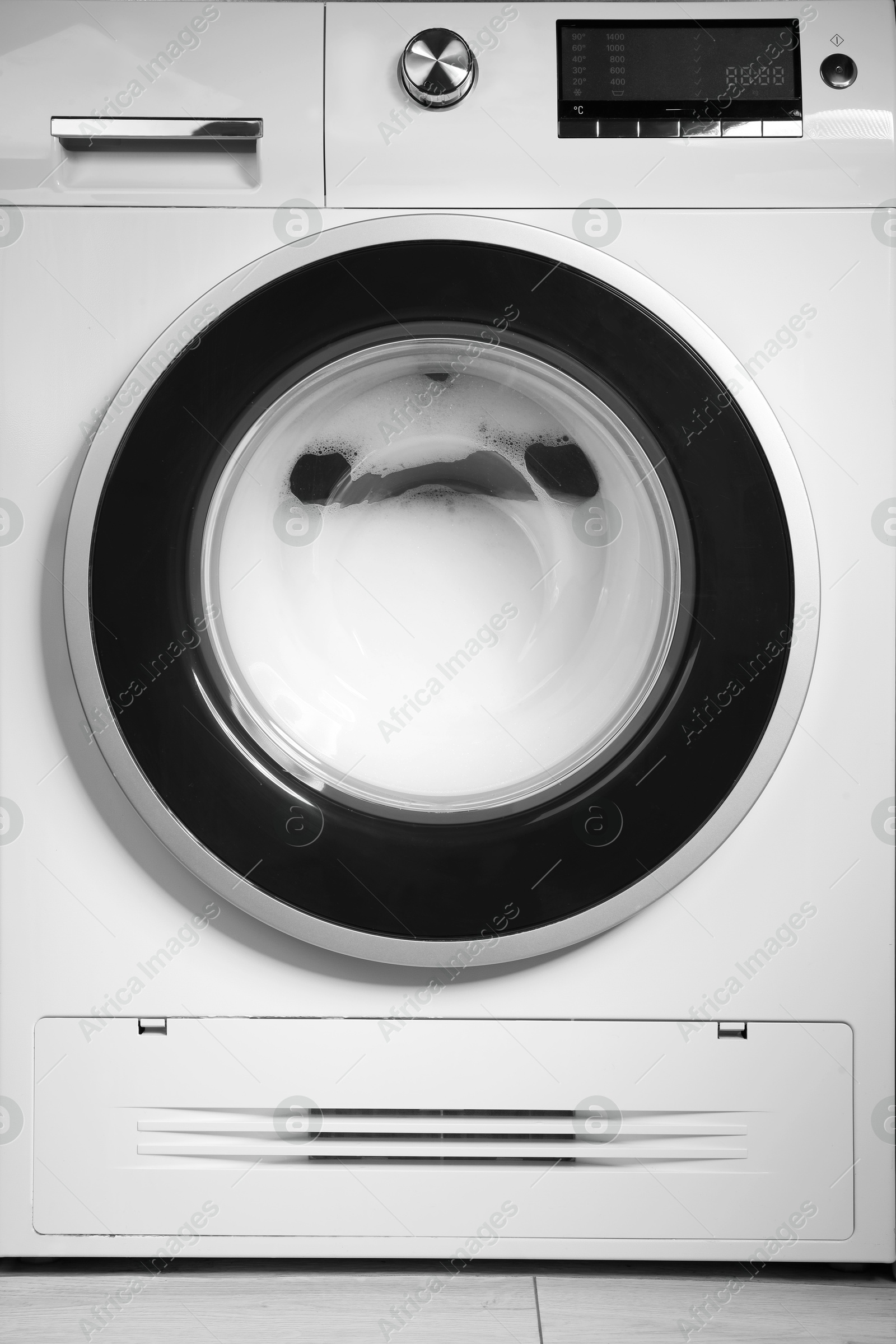 Photo of Washing machine with suds as background, closeup