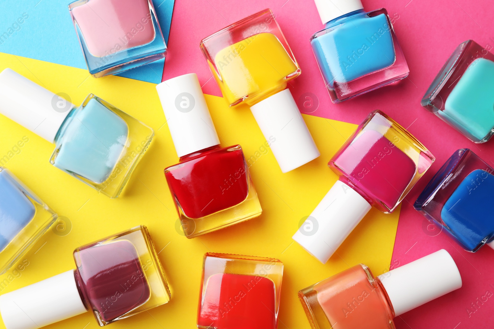 Photo of Set of different nail polishes on color background, flat lay