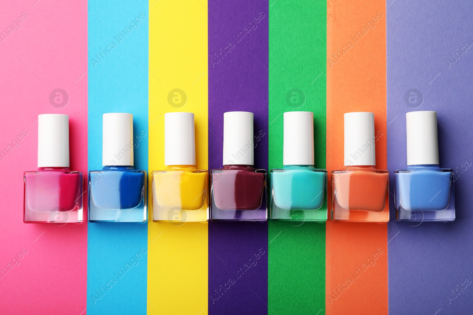 Photo of Set of different nail polishes on color background, flat lay