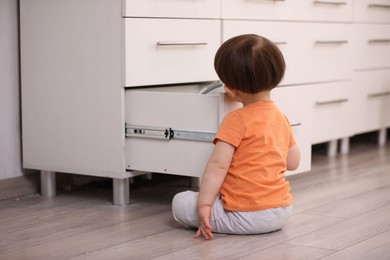 Photo of Little boy playing with kitchen appliances indoors. Dangerous situation