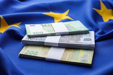 Photo of Euro banknotes on European Union flag, closeup