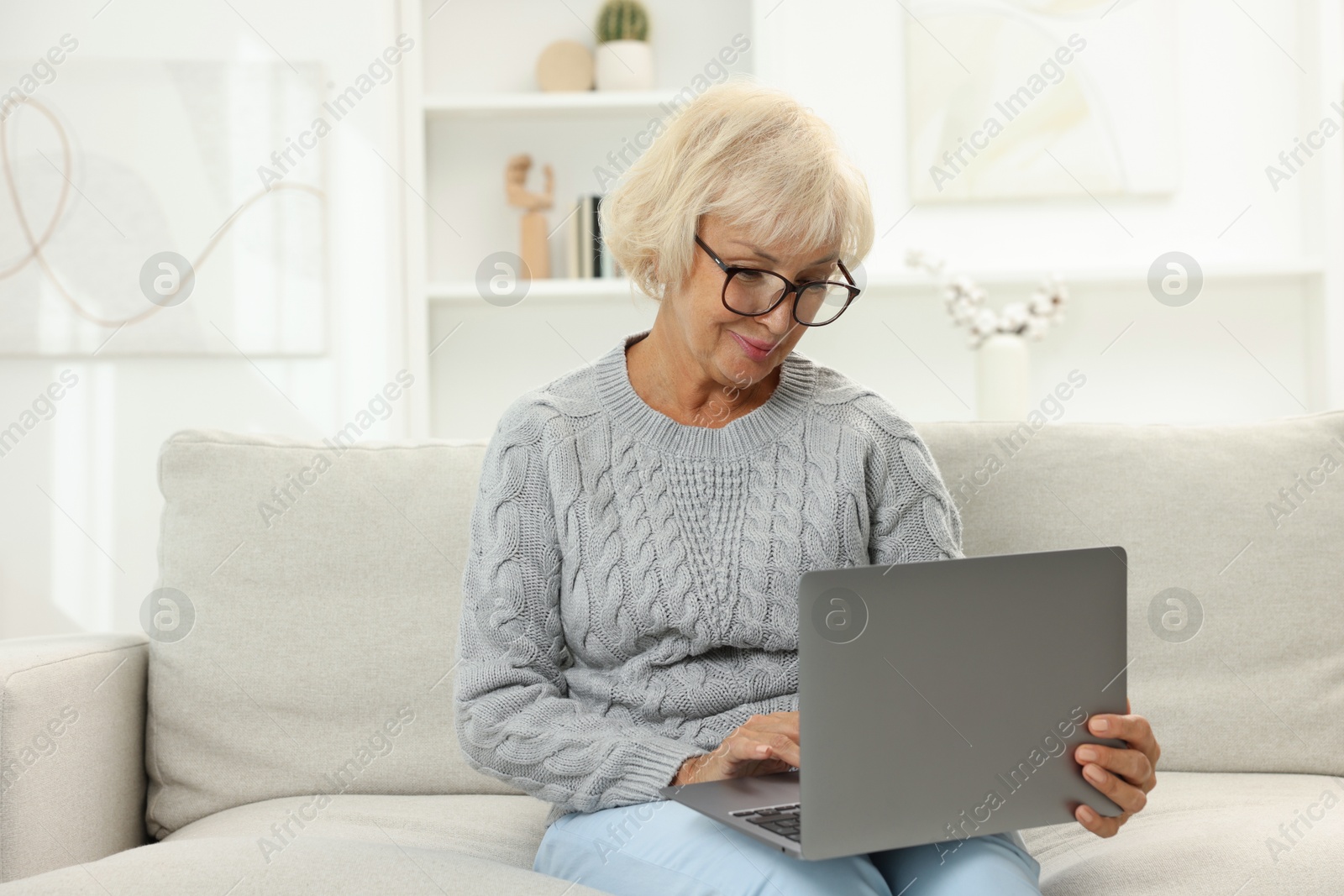 Photo of Beautiful senior woman using laptop at home