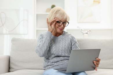 Photo of Beautiful senior woman using laptop at home