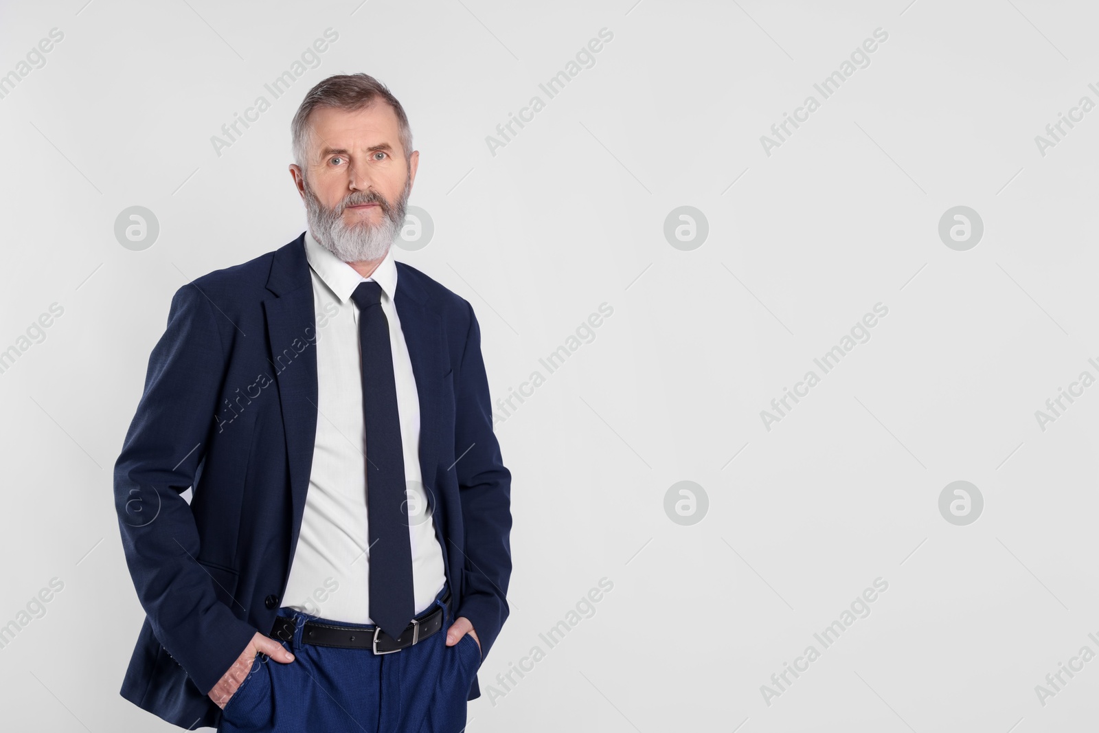 Photo of Portrait of senior man in suit on white background, space for text