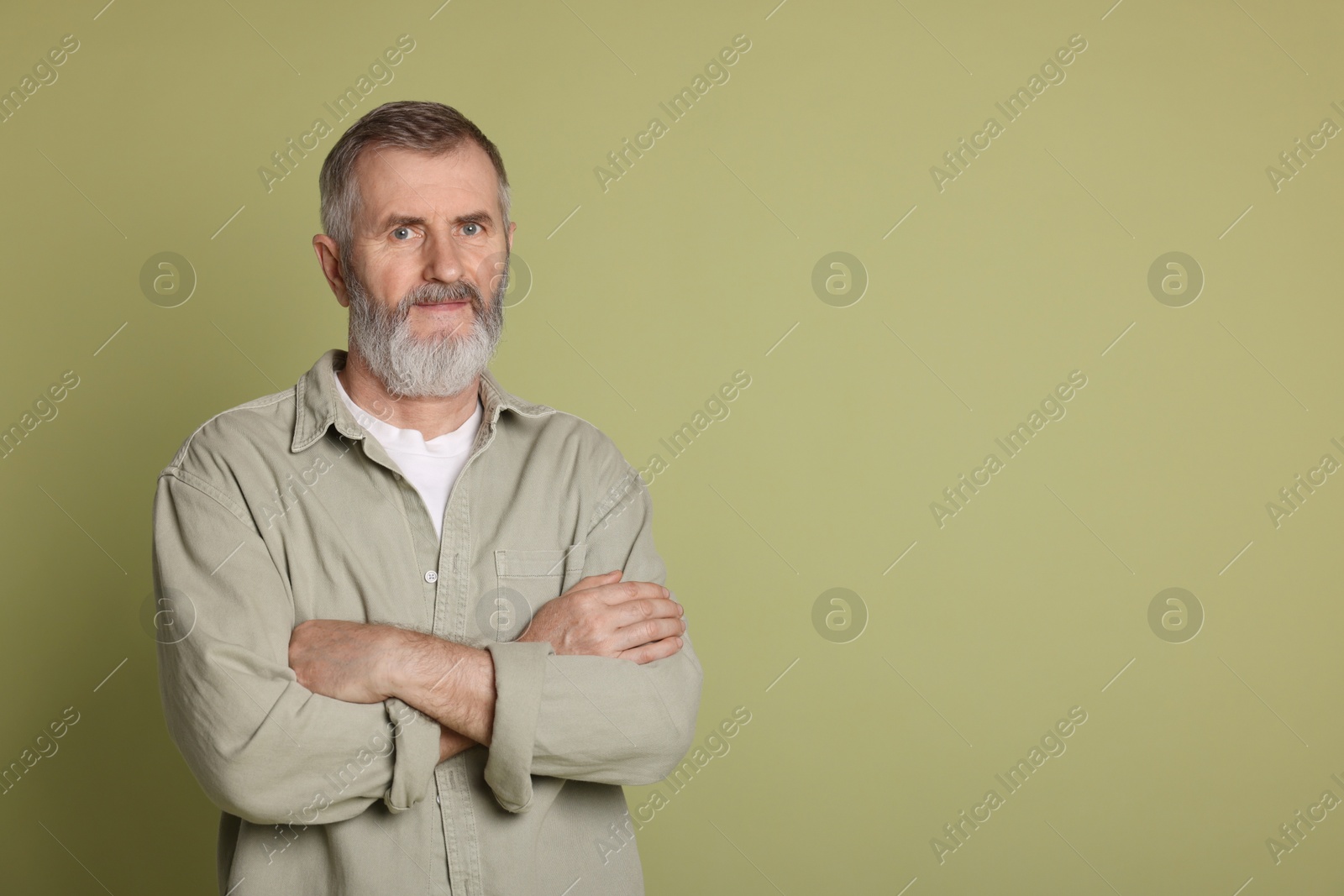 Photo of Portrait of senior man on green background, space for text