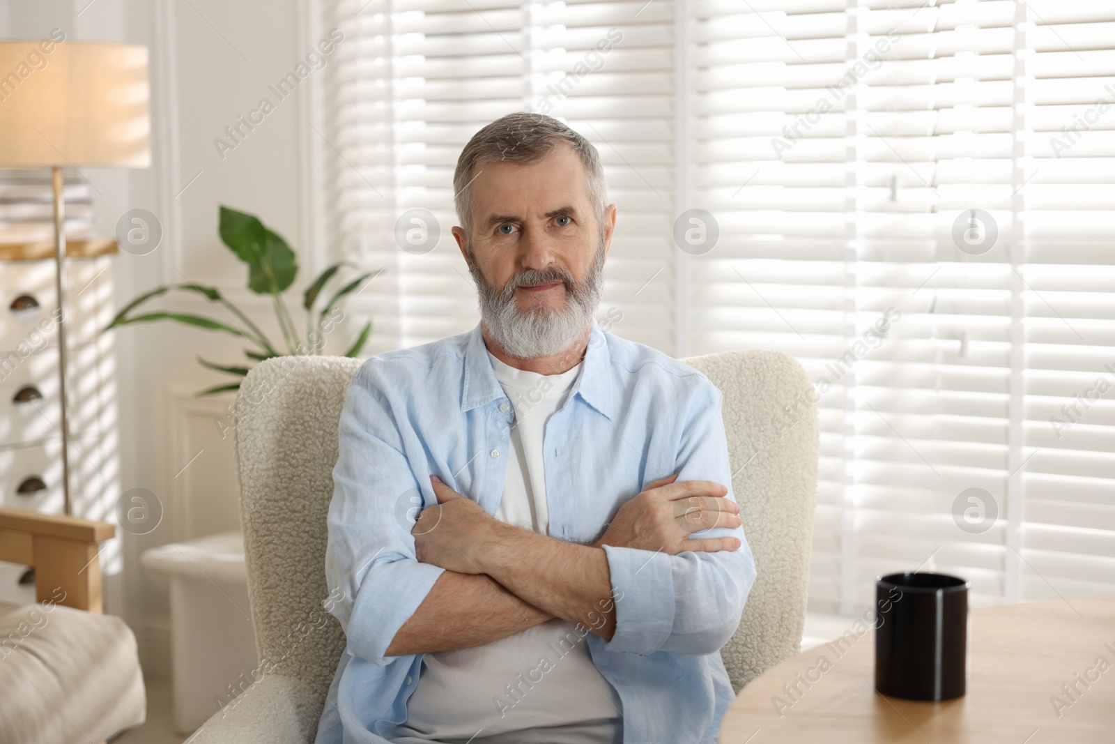 Photo of Portrait of senior man in armchair at home