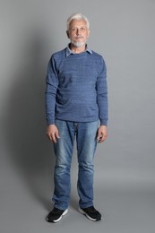 Photo of Full length portrait of senior man on grey background