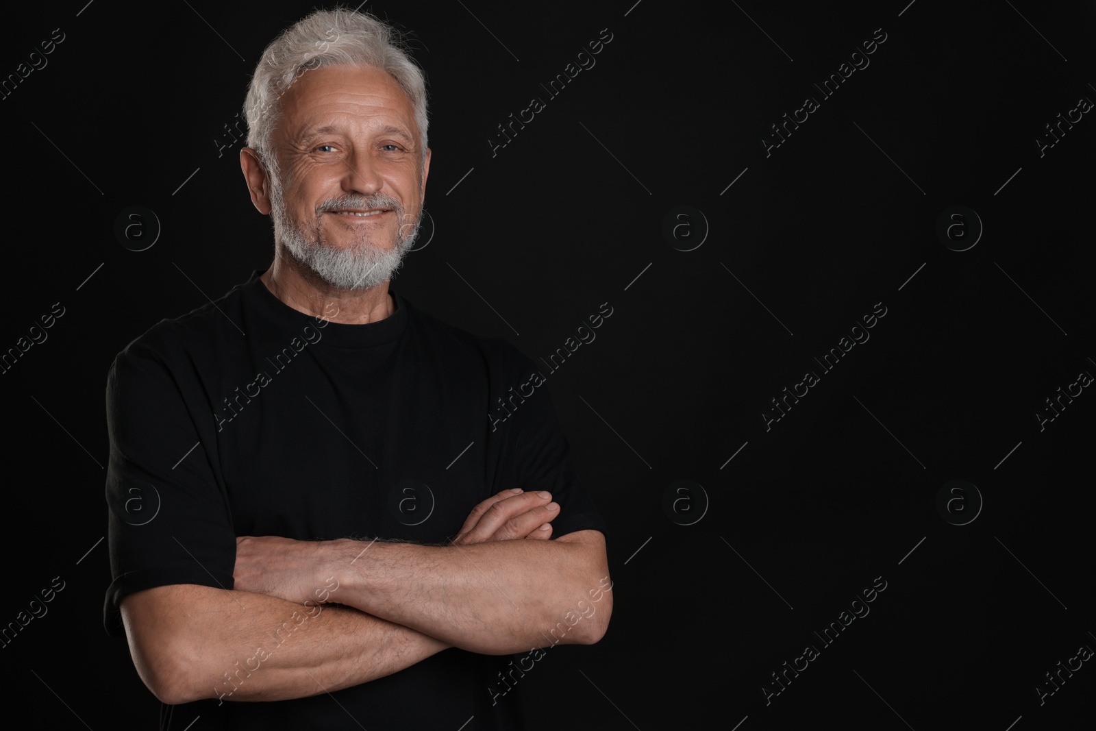 Photo of Portrait of senior man on black background, space for text