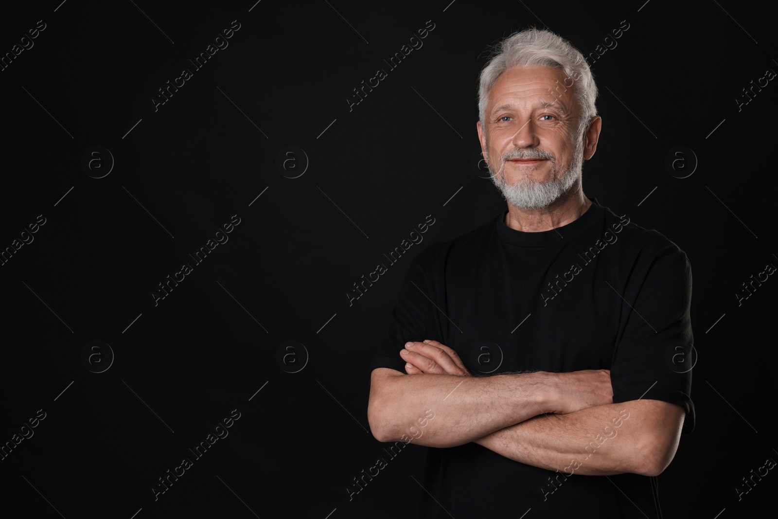 Photo of Portrait of senior man on black background, space for text