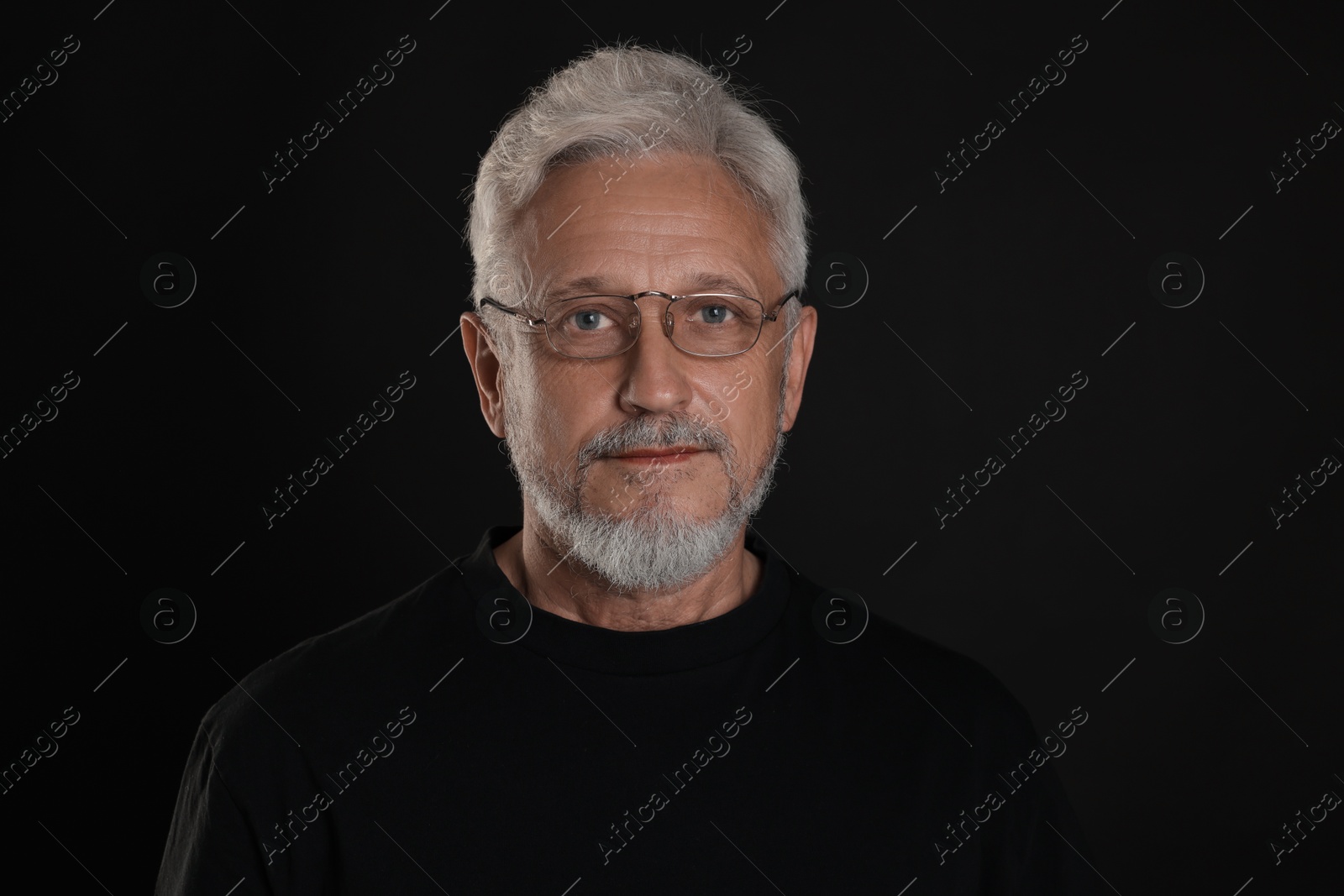 Photo of Portrait of senior man on black background