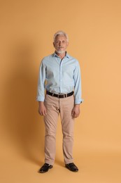 Photo of Full length portrait of senior man on beige background