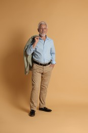 Photo of Full length portrait of senior man on beige background