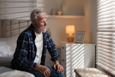 Photo of Portrait of senior man with grey hair at home, space for text