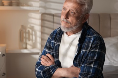 Photo of Portrait of senior man with grey hair at home