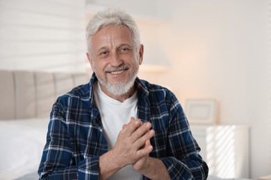 Photo of Portrait of senior man with grey hair at home