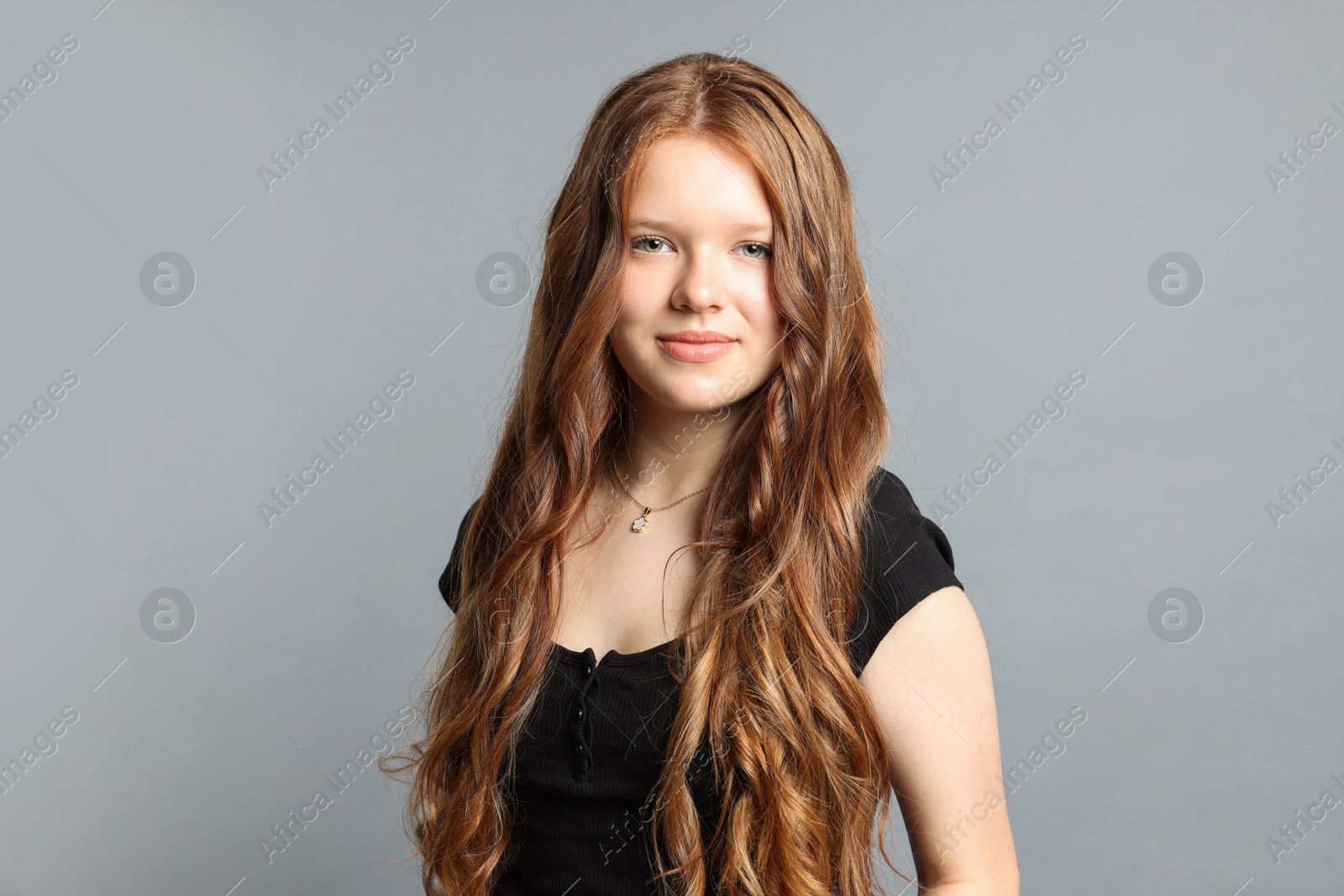 Photo of Teenage girl with healthy long hair on light grey background