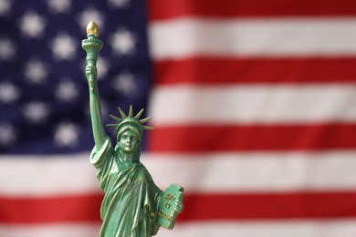 Photo of Statue of Liberty against flag of USA, closeup. Space for text