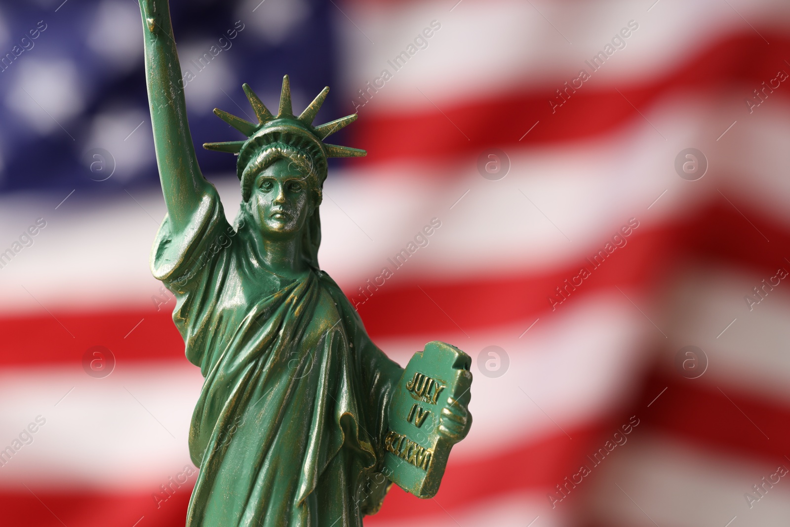 Photo of Statue of Liberty against flag of USA, closeup. Space for text