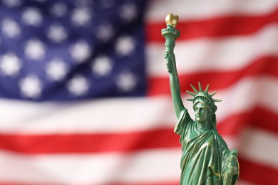 Photo of Statue of Liberty against flag of USA, closeup. Space for text