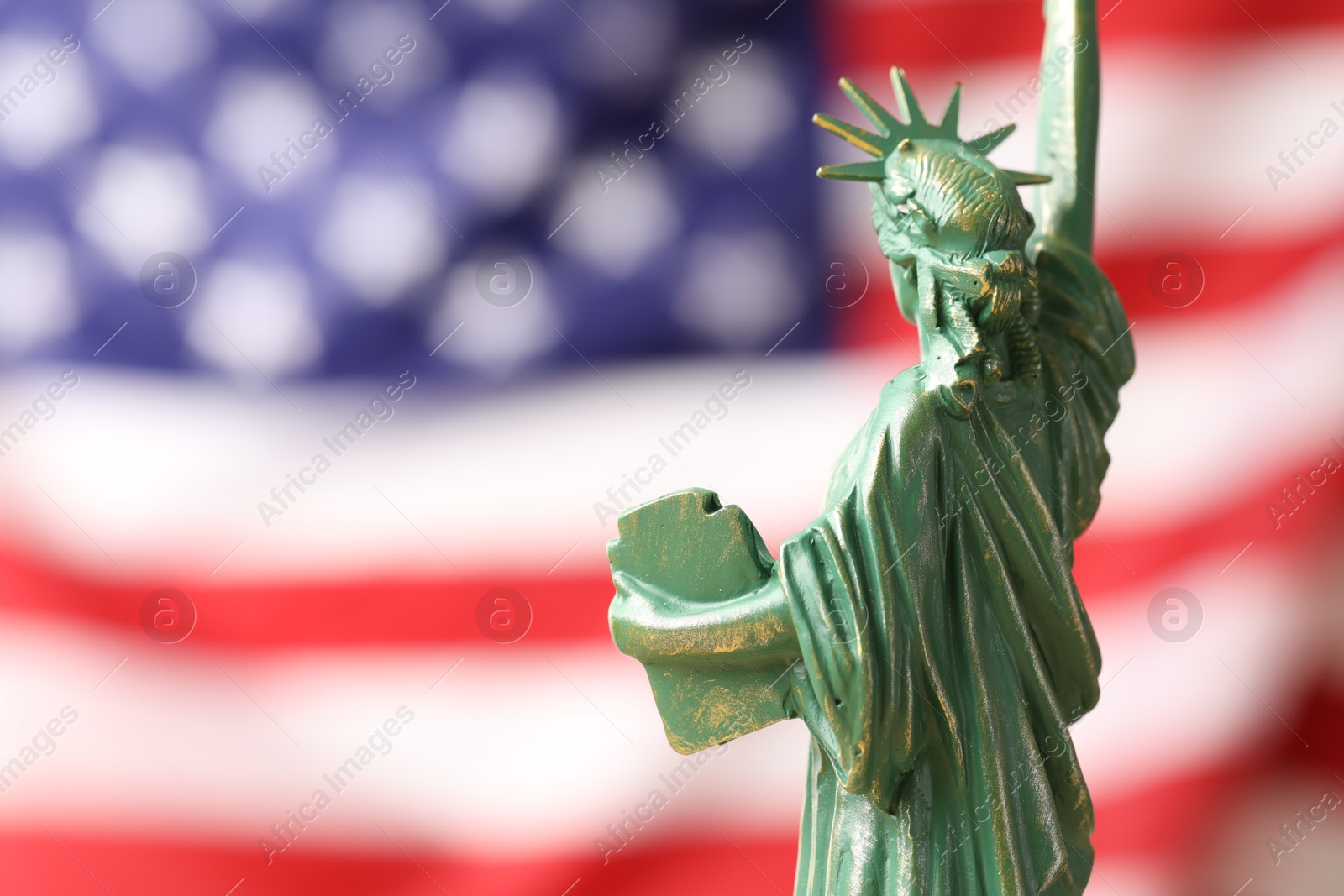 Photo of Statue of Liberty against flag of USA, closeup. Space for text