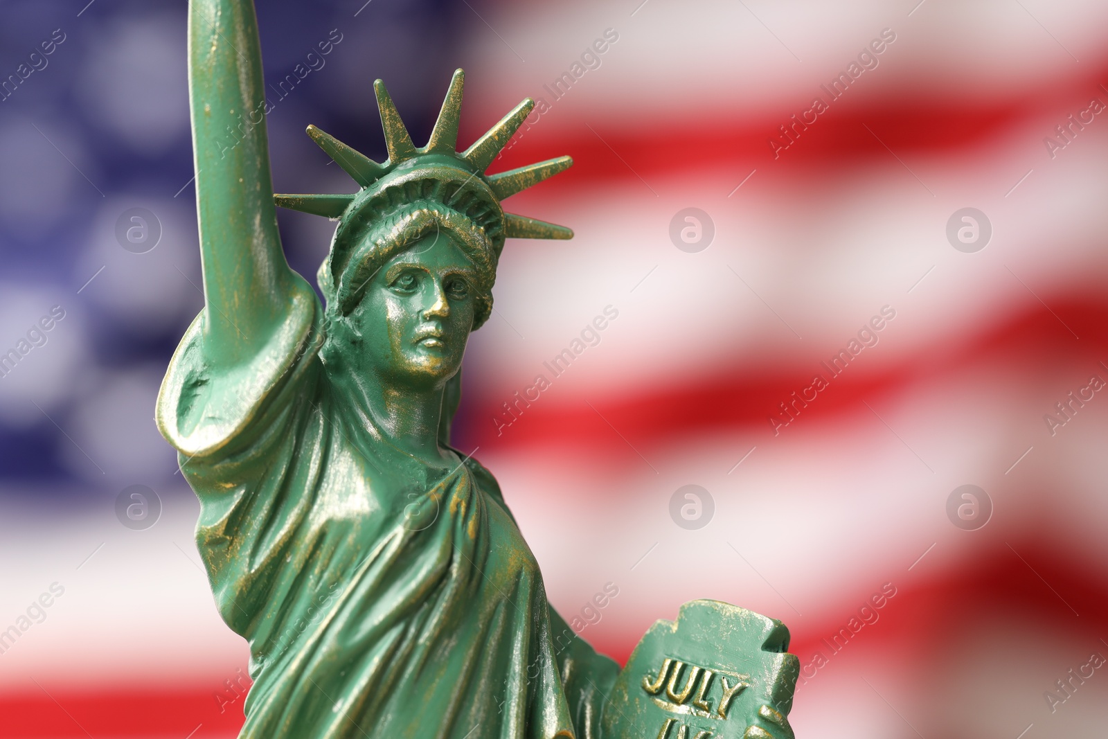 Photo of Statue of Liberty against flag of USA, closeup. Space for text