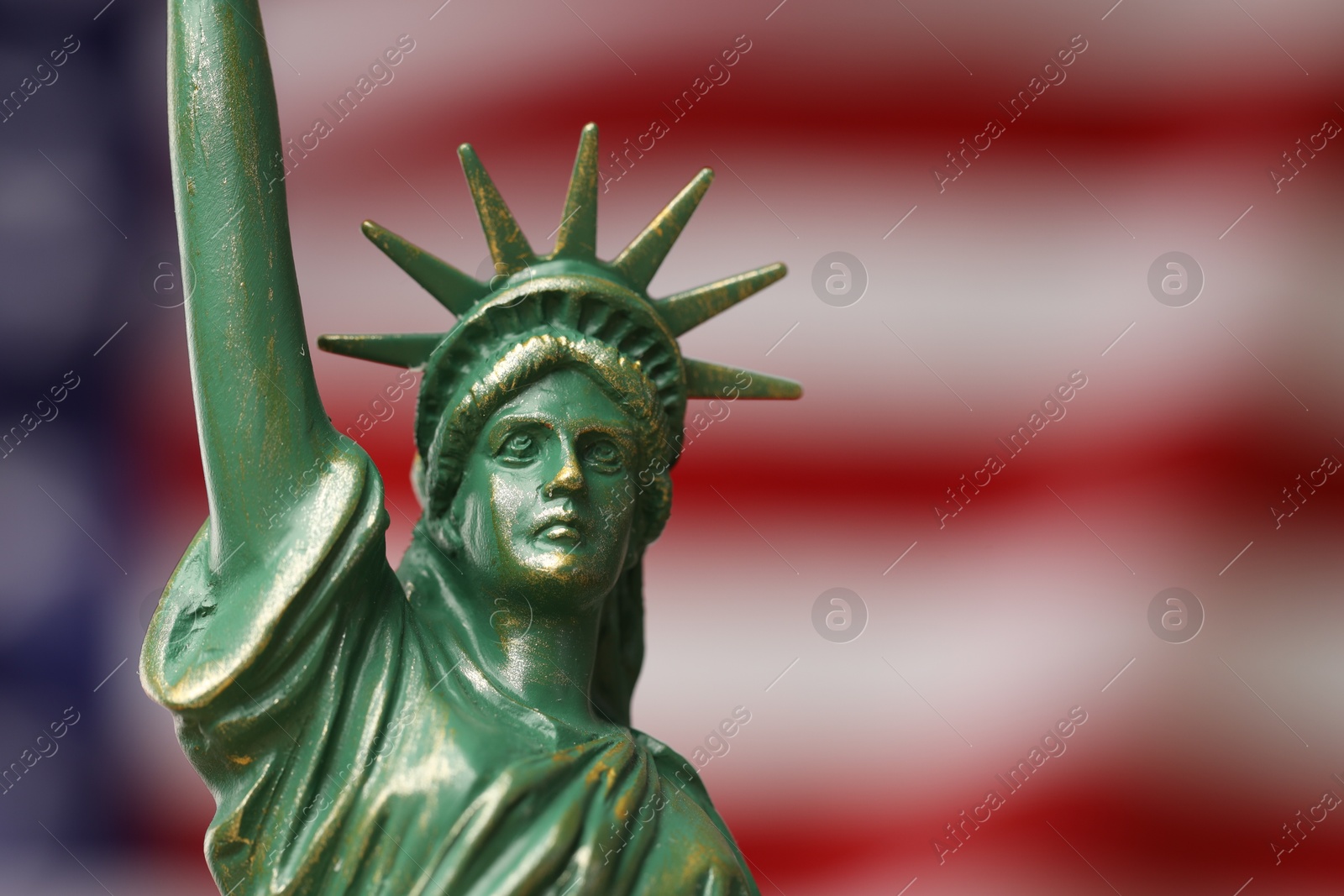 Photo of Statue of Liberty against flag of USA, closeup. Space for text