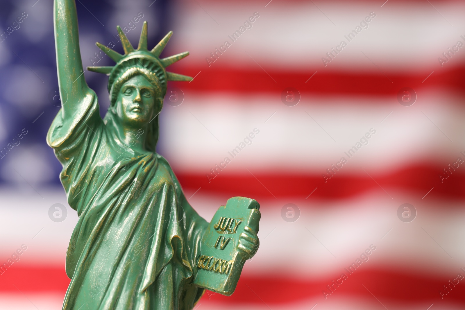 Photo of Statue of Liberty against flag of USA, closeup. Space for text