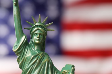 Photo of Statue of Liberty against flag of USA, closeup. Space for text