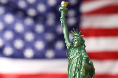 Photo of Statue of Liberty against flag of USA, closeup. Space for text