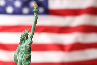 Photo of Statue of Liberty against flag of USA, closeup. Space for text