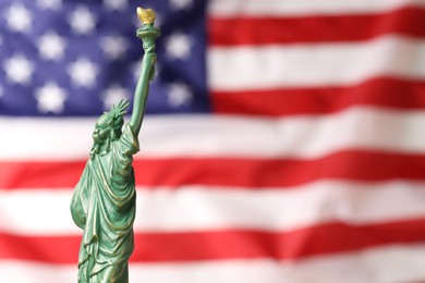 Photo of Statue of Liberty against flag of USA, closeup. Space for text