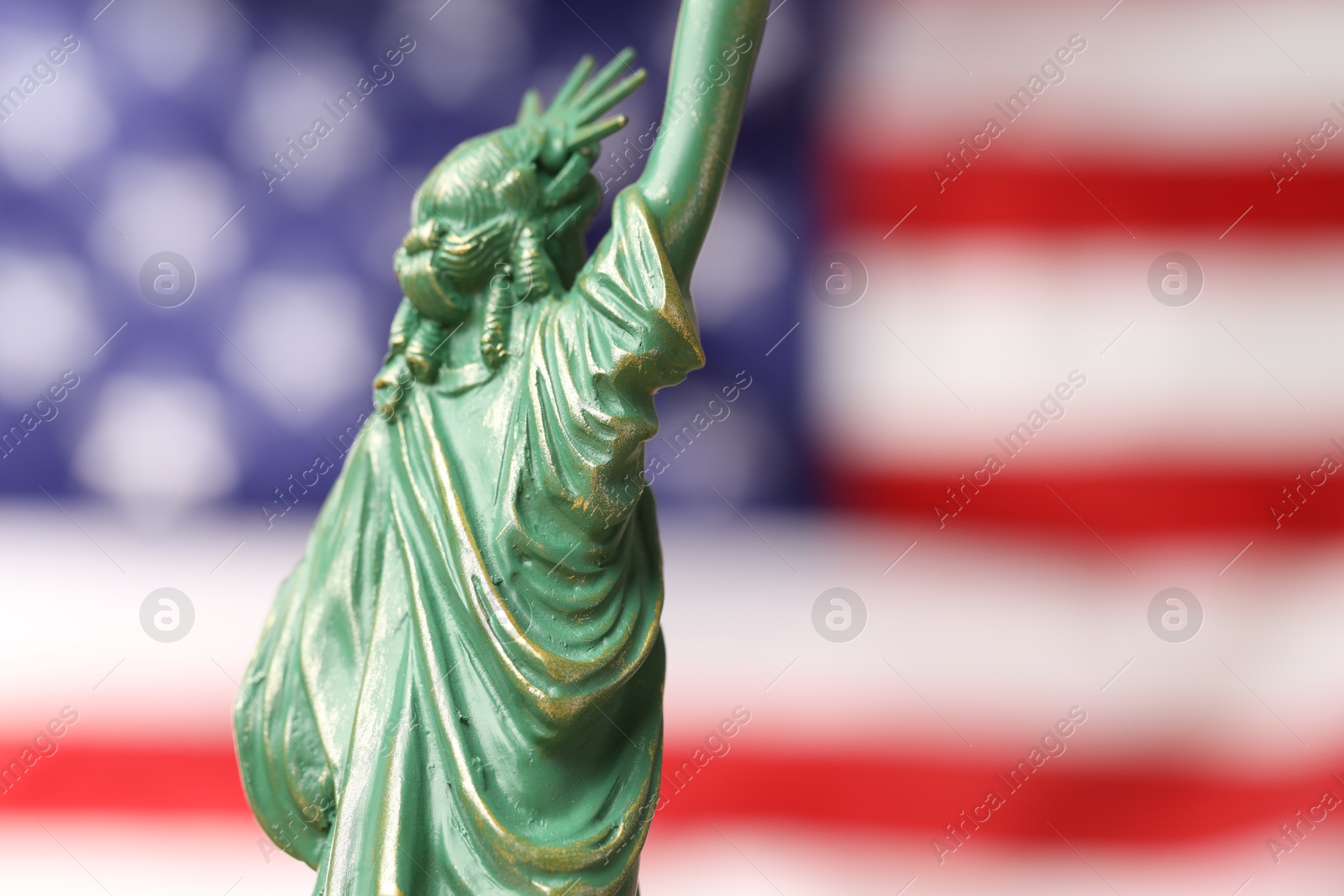 Photo of Statue of Liberty against flag of USA, closeup. Space for text