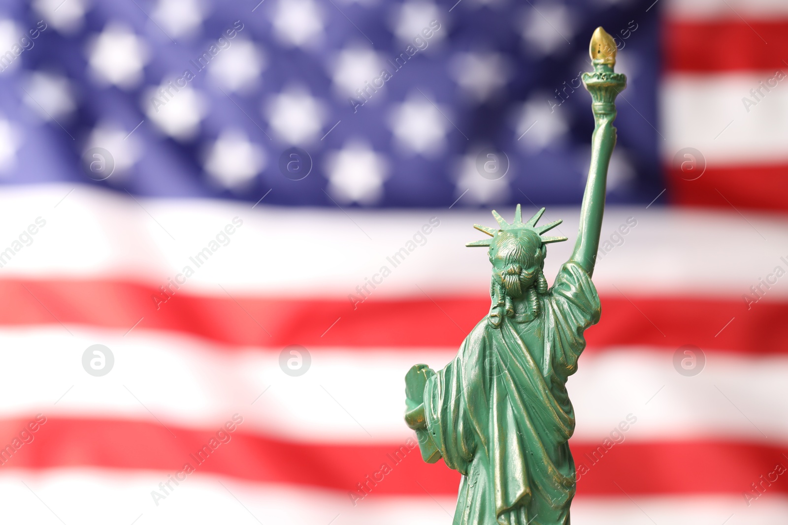 Photo of Statue of Liberty against flag of USA, closeup. Space for text