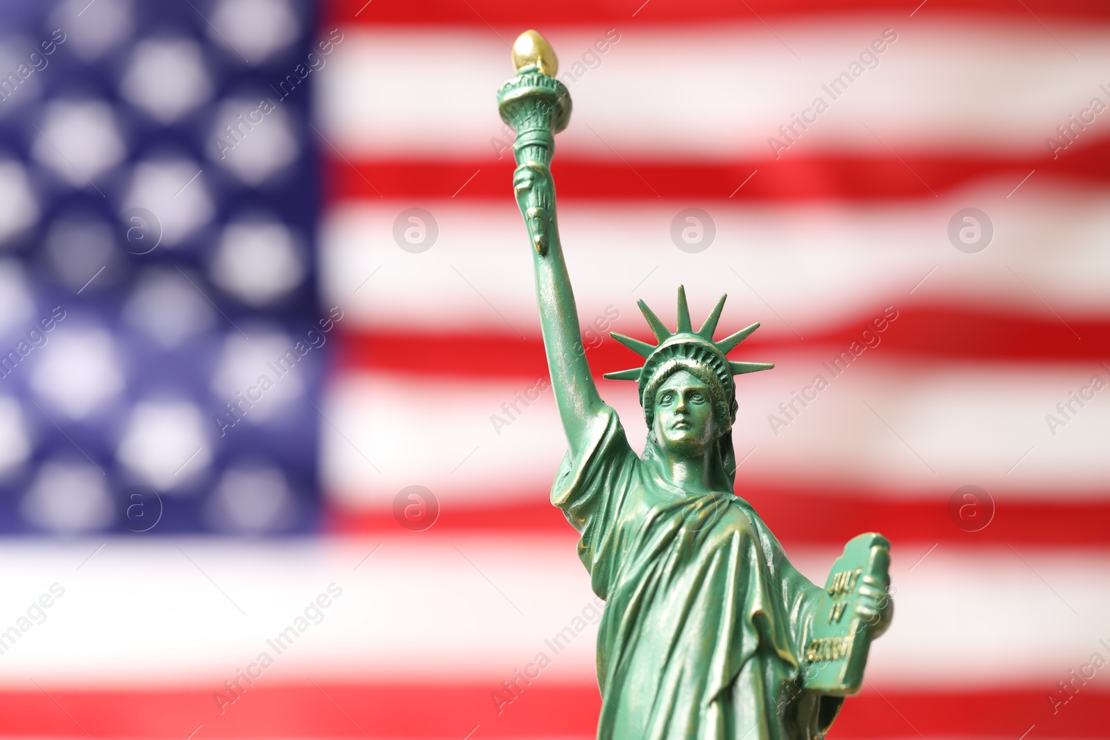 Photo of Statue of Liberty against flag of USA, closeup. Space for text