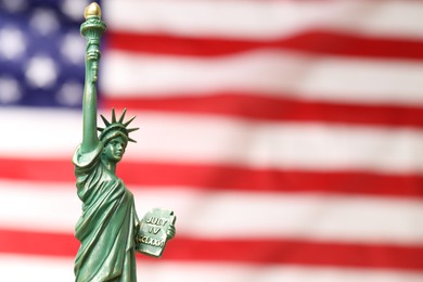 Photo of Statue of Liberty against flag of USA, closeup. Space for text