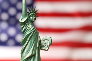 Photo of Statue of Liberty against flag of USA, closeup. Space for text