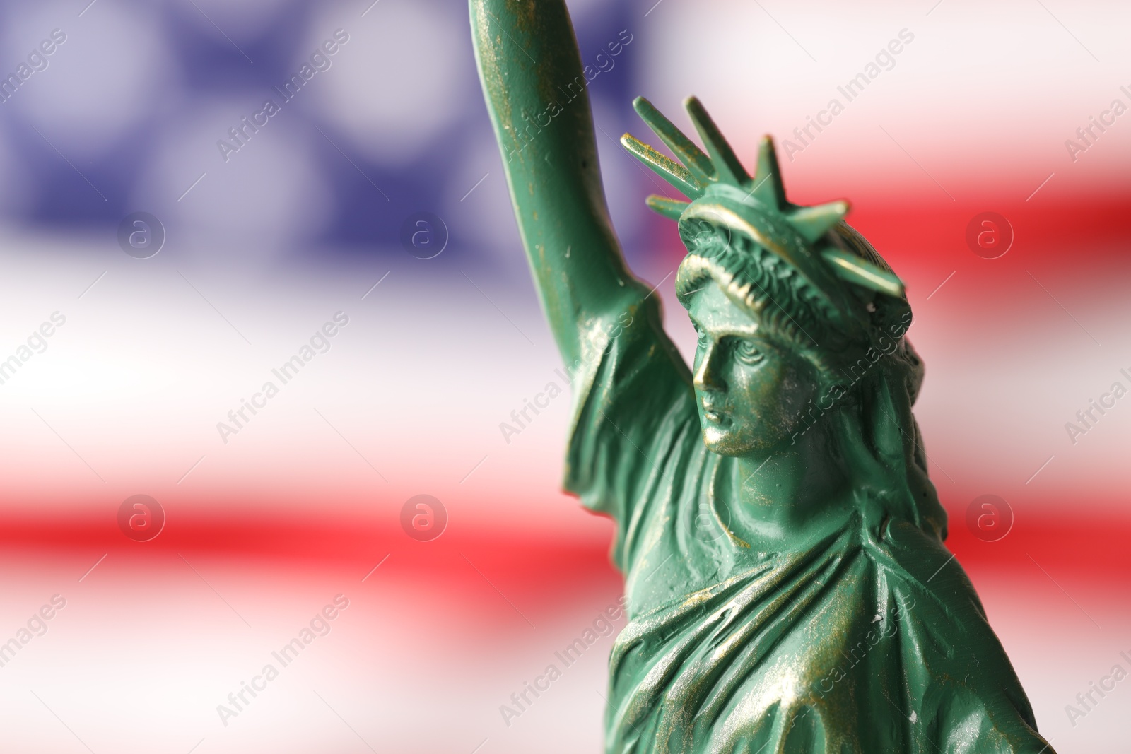 Photo of Statue of Liberty against flag of USA, closeup. Space for text