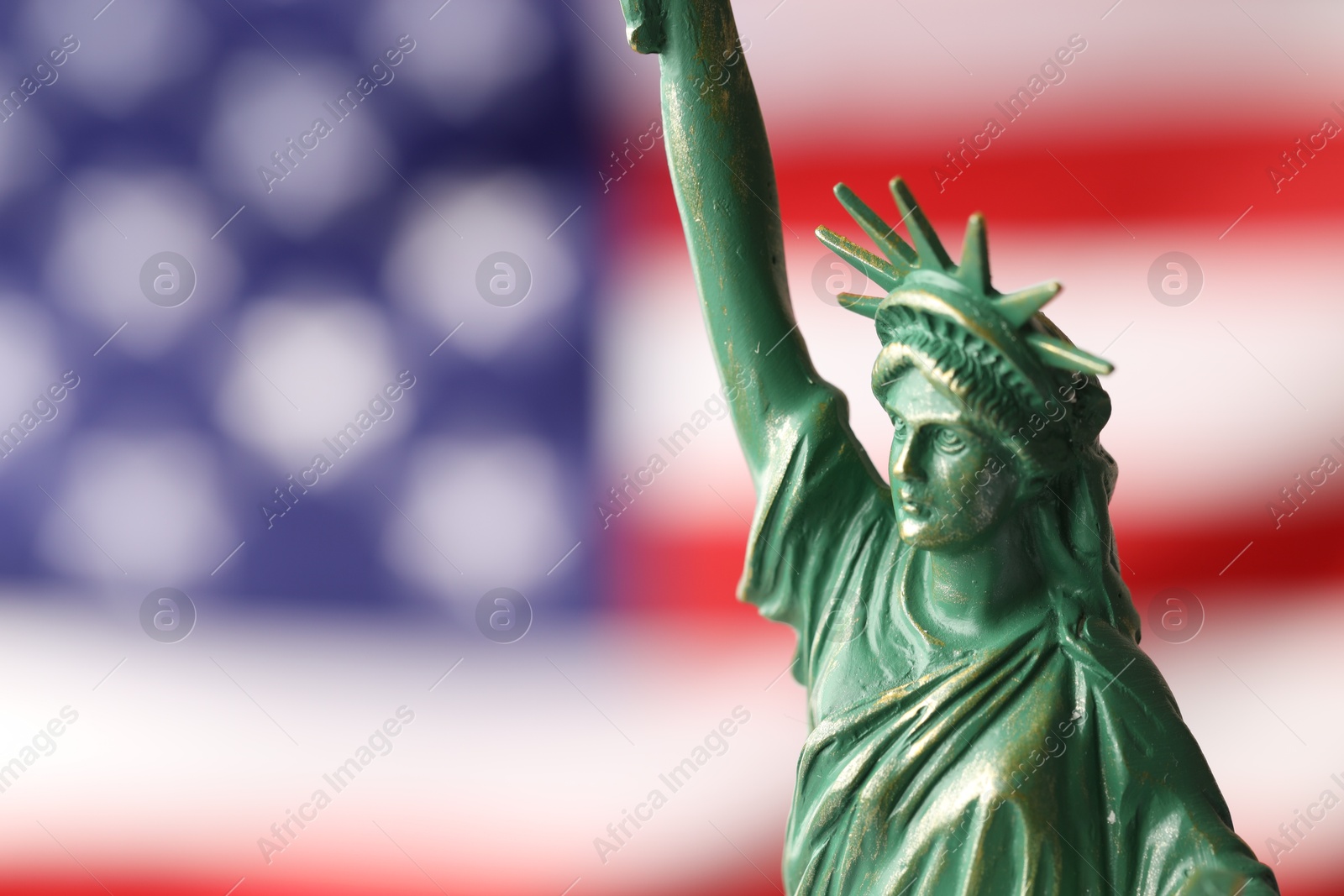 Photo of Statue of Liberty against flag of USA, closeup. Space for text