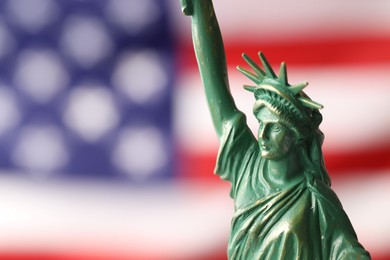 Photo of Statue of Liberty against flag of USA, closeup. Space for text