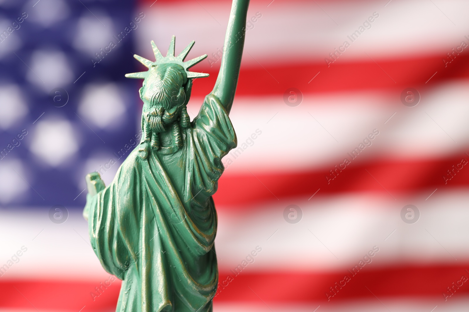 Photo of Statue of Liberty against flag of USA, closeup. Space for text