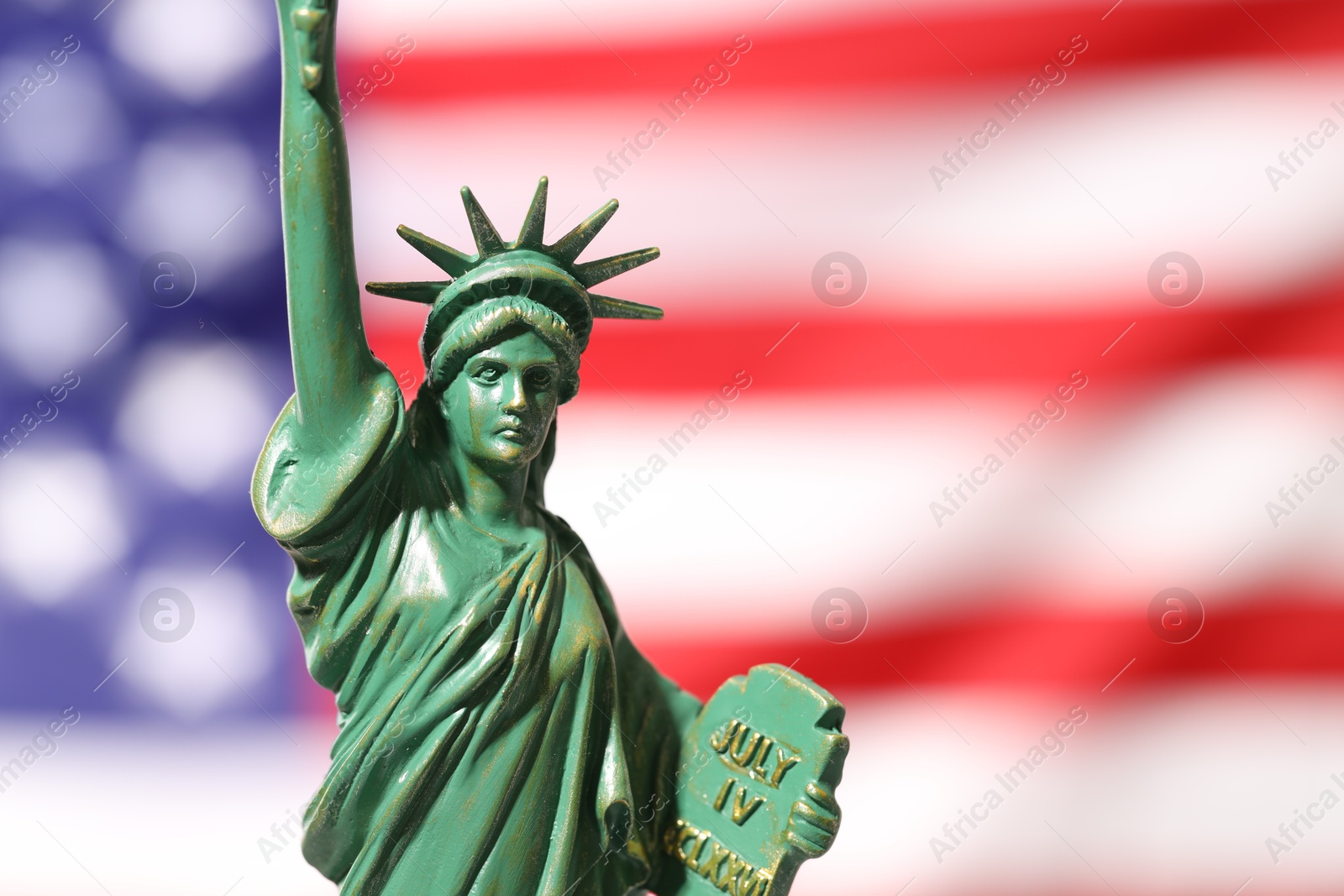 Photo of Statue of Liberty against flag of USA, closeup. Space for text