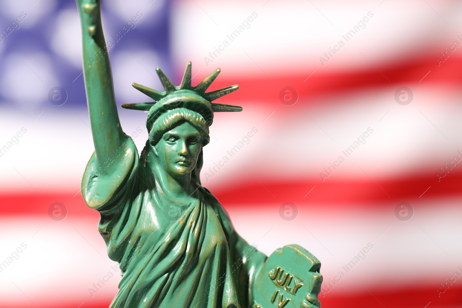 Photo of Statue of Liberty against flag of USA, closeup. Space for text