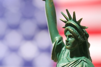 Photo of Statue of Liberty against flag of USA, closeup. Space for text