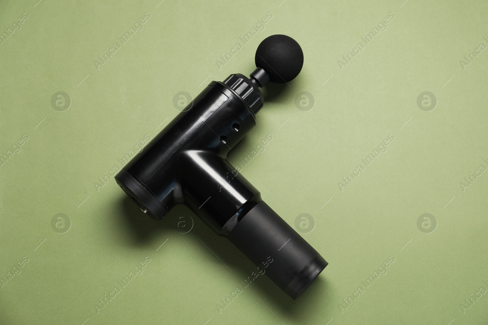 Photo of One black percussive massager on olive background, top view